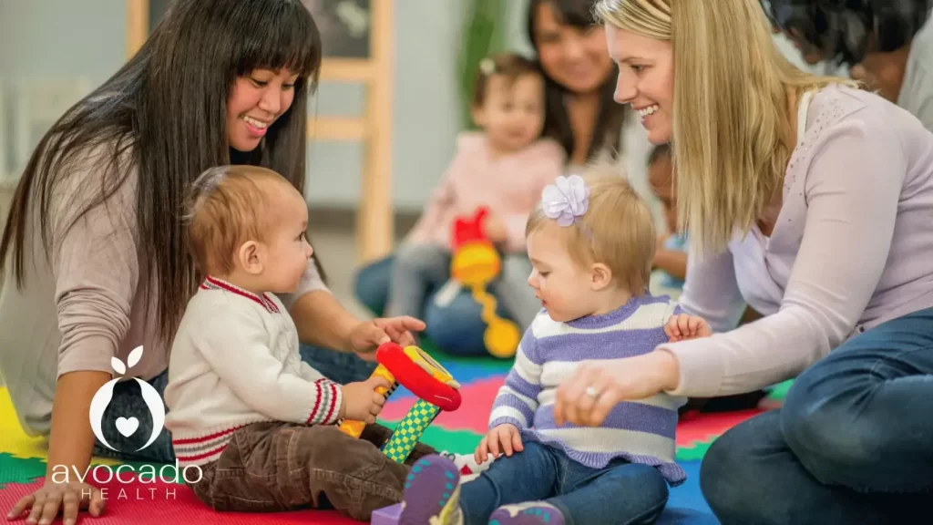 How to deal with separation anxiety in toddlers: A teacher engages a child in an activity to help them adjust during drop-off